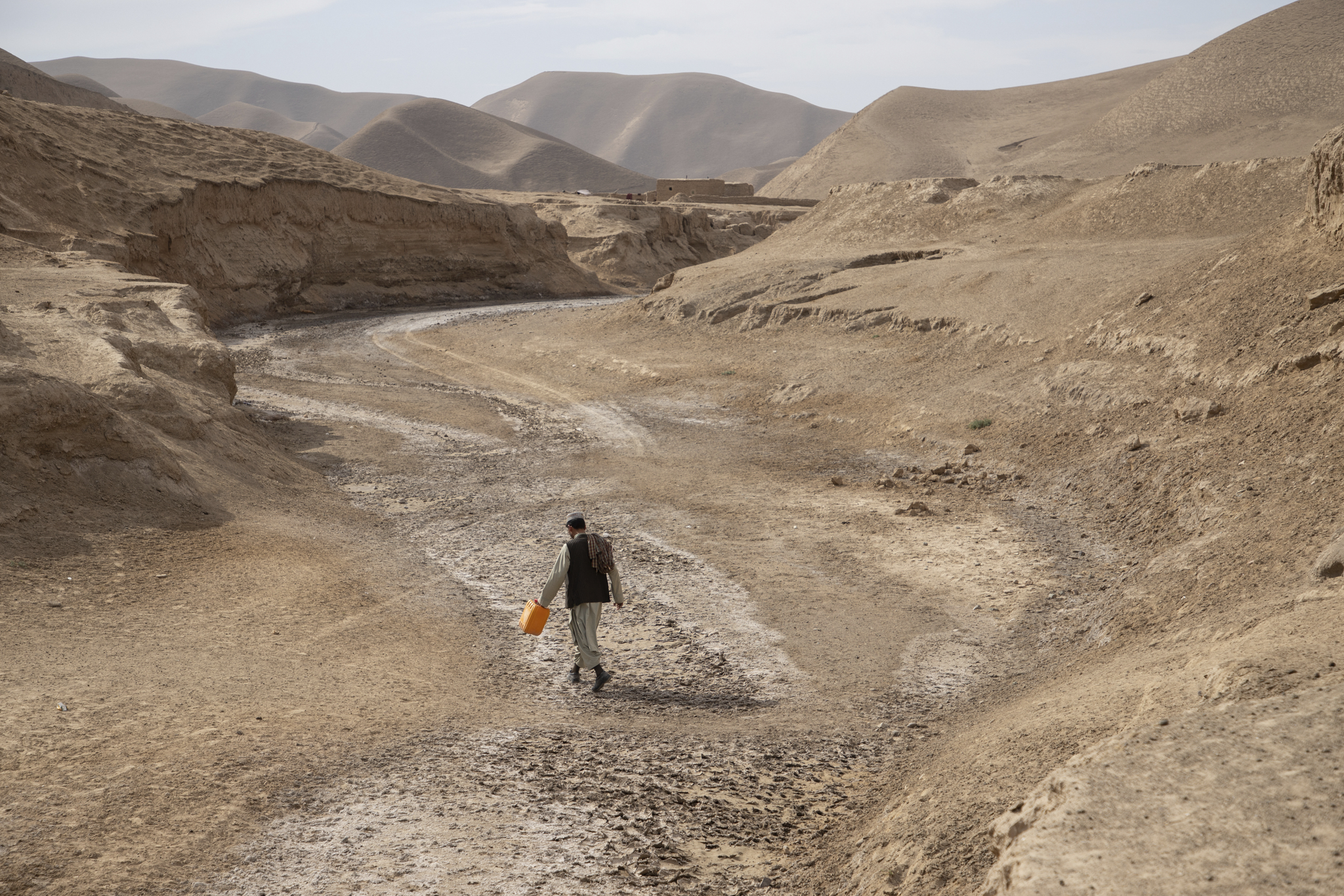 Muhammad Sadiq, 25, walks through a dry riverbed to find water for his family in Badghis, Afghanistan. Photo funded by the European Union.