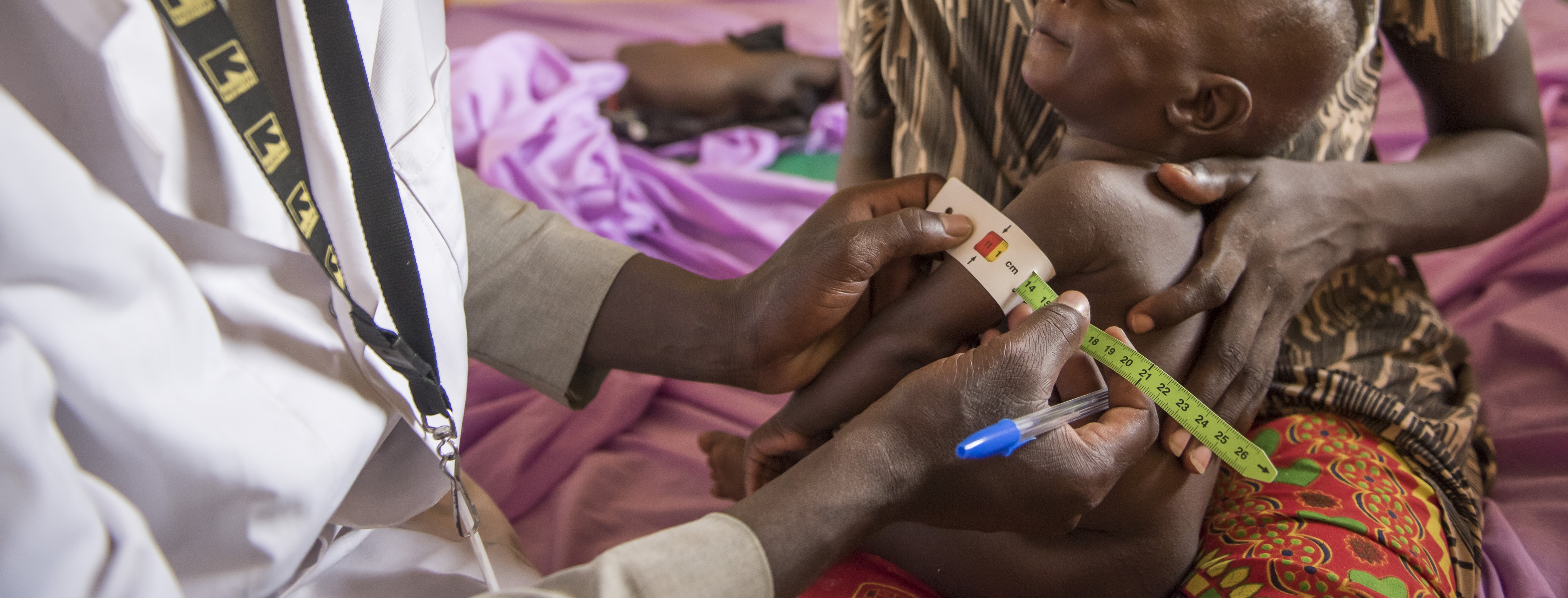 A healthcare worker measures a child's MUAC