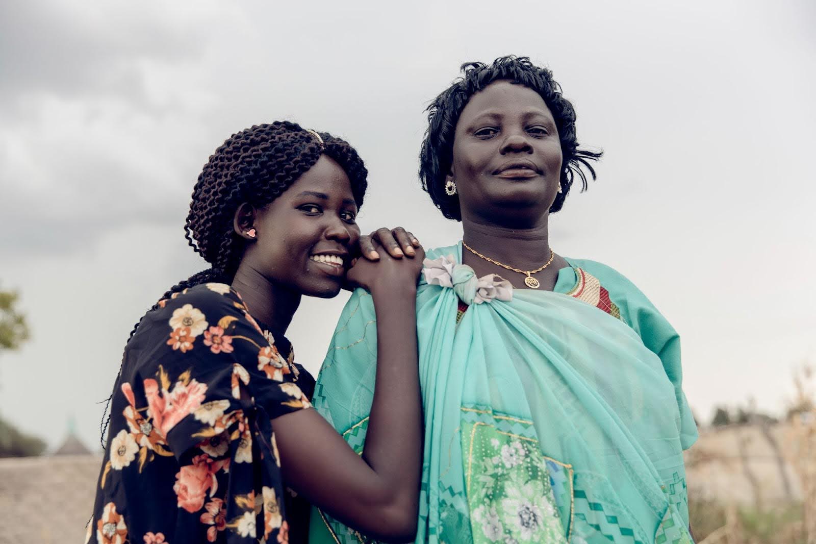 Nyanibioch Arop, 42, poses for a portrait with her support system, one of her daughters, in her compound in Jamjang, South Sudan, October 2021