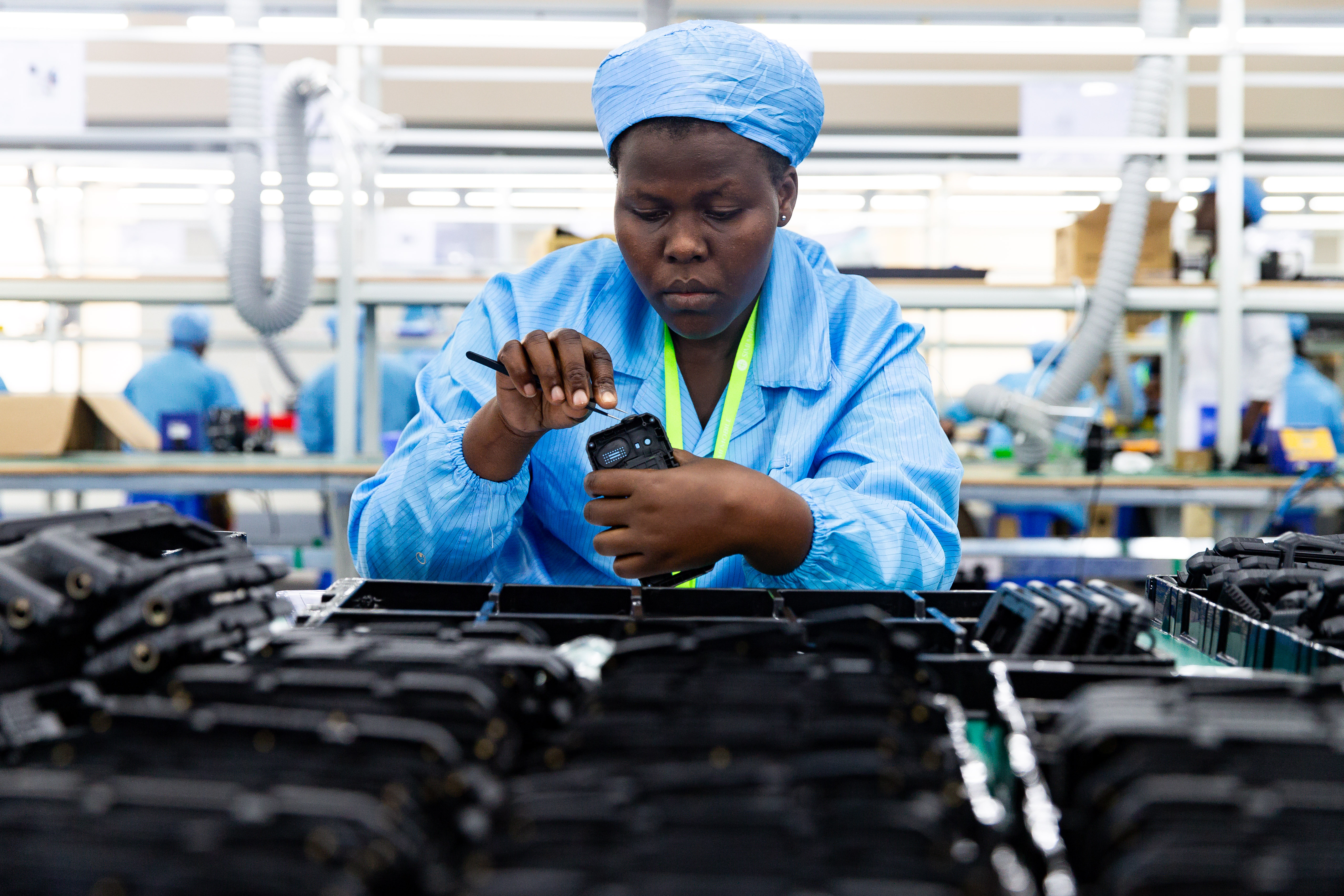 Worker assembles phone cases at Ugandan factory.